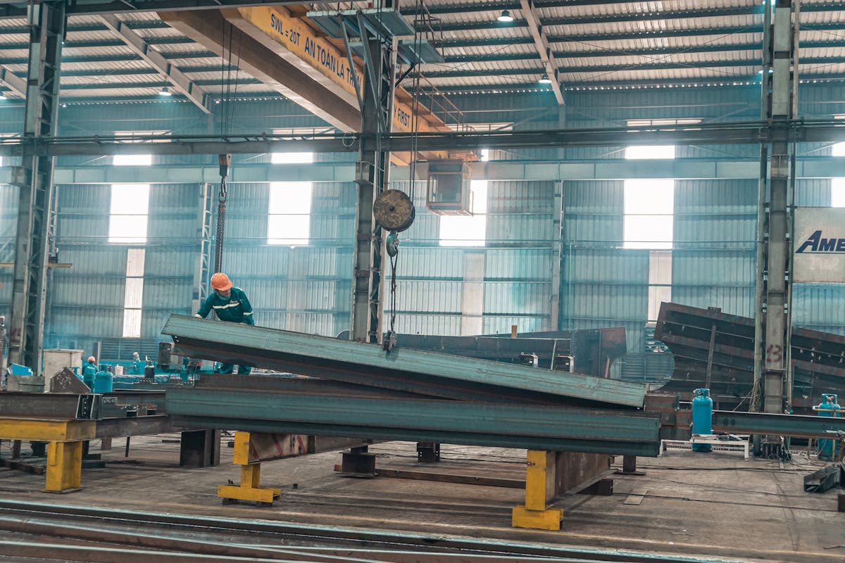 Chão de fábrica da Argos Industrial com ponte rolante movimentando estruturas de aço